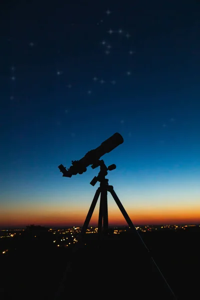 Silhueta de telescópio e céu noturno com luzes da cidade no backg — Fotografia de Stock
