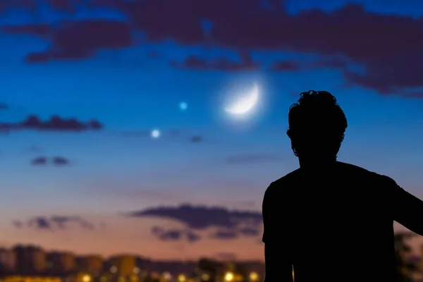Mann blickt vom Stadtgebiet in den Nachthimmel. — Stockfoto