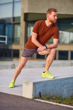 Genç adam şehir parkında egzersiz yapıyor / esniyor.