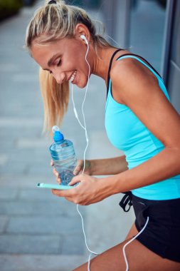 Kentsel alanda koştuktan sonra modern sporcu kadın durakladı.