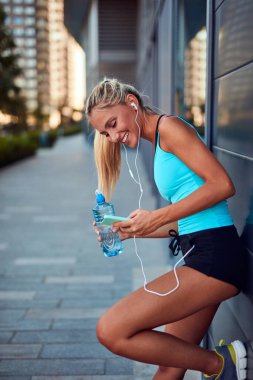 Kentsel alanda koştuktan sonra modern sporcu kadın durakladı.