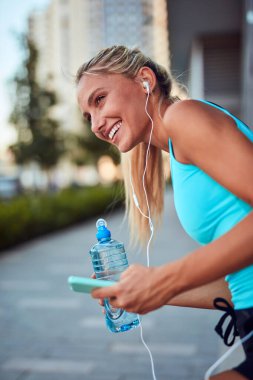 Kentsel alanda koştuktan sonra modern sporcu kadın durakladı.