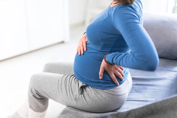 Zwanger vermoeide, vermoeide vrouw met maagklachten en rugpijn — Stockfoto