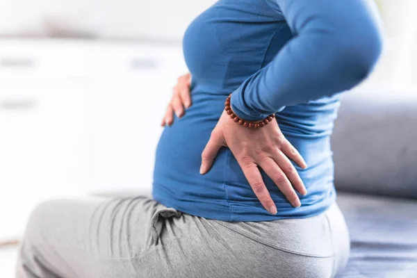 Schwangere müde erschöpfte Frau mit Magenproblemen und Rückenschmerzen — Stockfoto