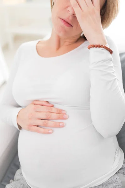 Zwanger vermoeide, vermoeide vrouw met maag- en hoofdproblemen bij h — Stockfoto