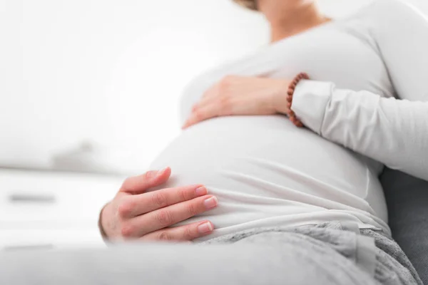 Zwanger vermoeide, vermoeide vrouw met maag- en hoofdproblemen bij h — Stockfoto