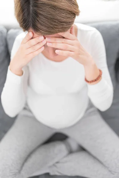 Zwanger vermoeide, vermoeide vrouw met maag- en hoofdproblemen bij h — Stockfoto