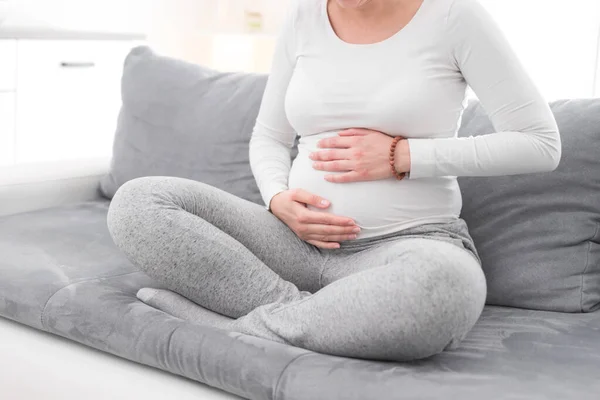 Embarazada cansada mujer agotada con problemas estomacales en casa en un —  Fotos de Stock
