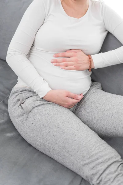 Zwanger vermoeide vermoeide vrouw met maagproblemen thuis op een — Stockfoto