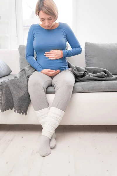 Schwangere müde erschöpfte Frau mit Magenproblemen und Rückenschmerzen — Stockfoto