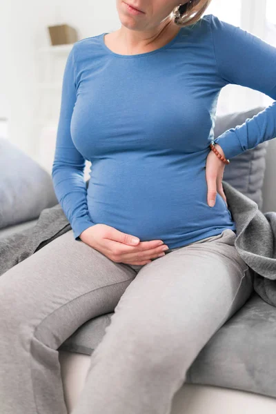 Mujer cansada y cansada embarazada con problemas estomacales y dolor de espalda —  Fotos de Stock