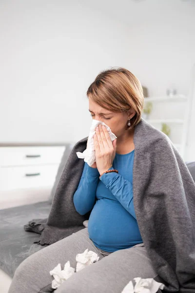 Mujer embarazada contraer resfriado, gripe, virus, sentado en casa en una c — Foto de Stock