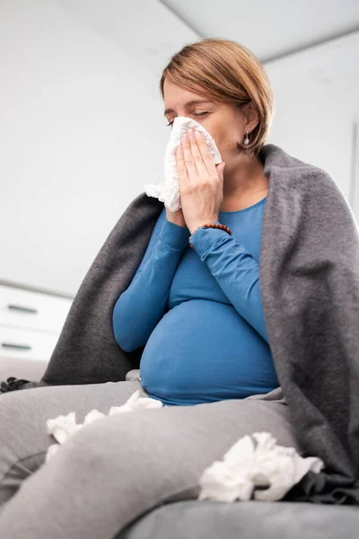 Mujer embarazada contraer resfriado, gripe, virus, sentado en casa en una c — Foto de Stock