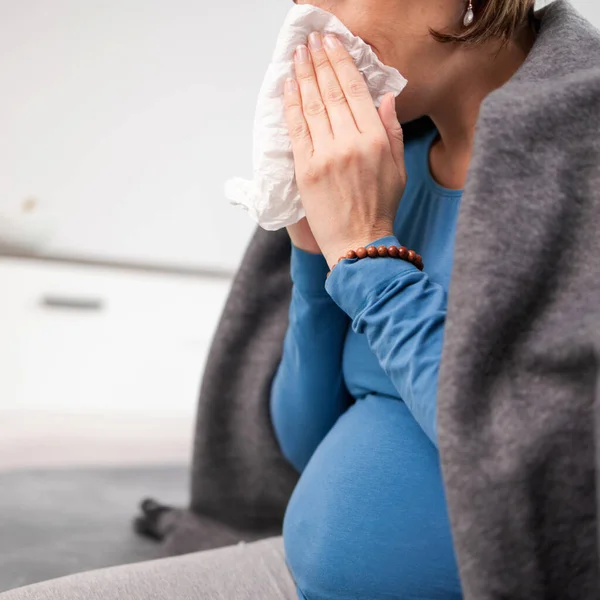 Mujer embarazada contraer resfriado, gripe, virus, sentado en casa en una c — Foto de Stock