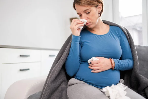 Mujer embarazada contraer resfriado, gripe, virus, sentado en casa en una c — Foto de Stock