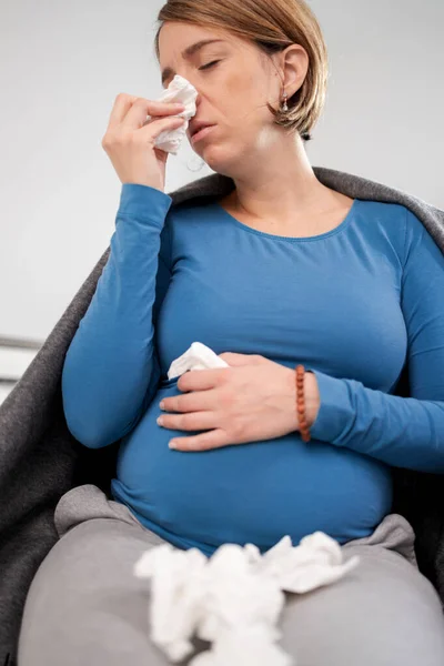 Mujer embarazada contraer resfriado, gripe, virus, sentado en casa en una c — Foto de Stock