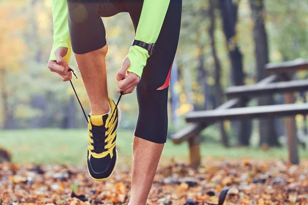 Preparing for jogging in autumn colored park. — Stock Photo, Image