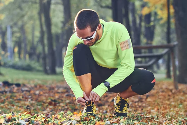 Przygotowanie do joggingu w jesiennym parku kolorowym. — Zdjęcie stockowe