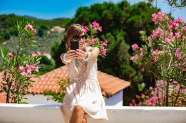 Sevimli genç kadın sokakta cep telefonu kullanarak.