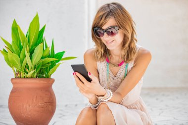 Sevimli genç kadın sokakta cep telefonu kullanarak.