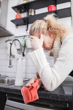 Kadın evi, mutfağı ve günlük ev işlerini temizlemekten yoruldu.
