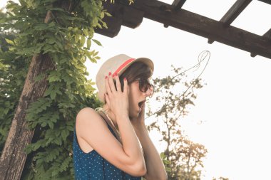 Yaz güneşinde dışarıda poz veren sevimli genç bir kadın..