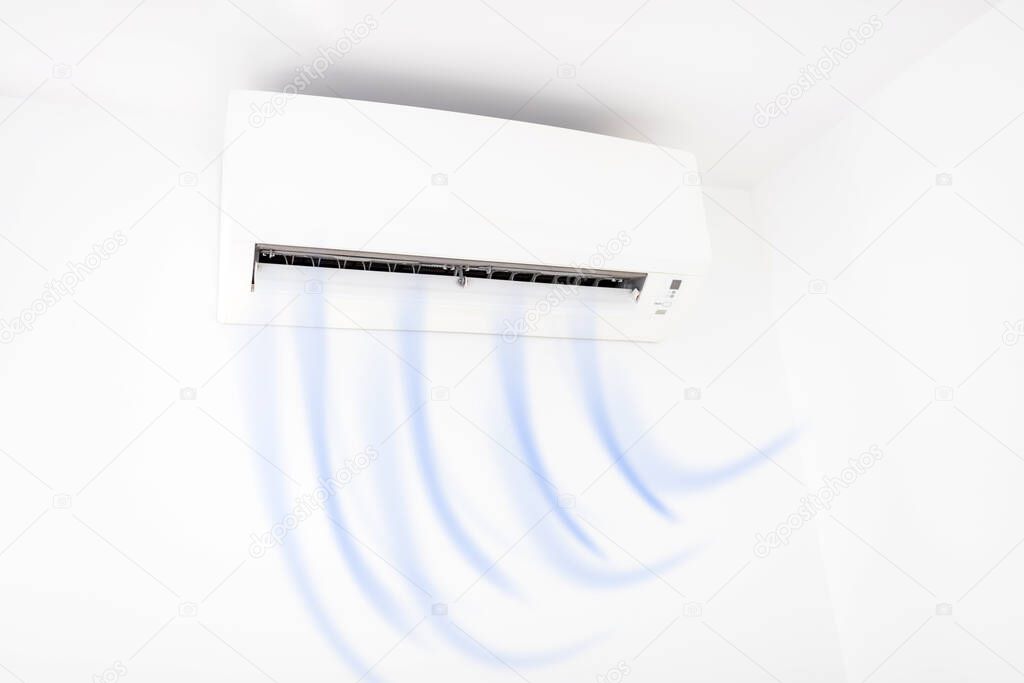 Modern air condition unit on a white wall inside the living room.