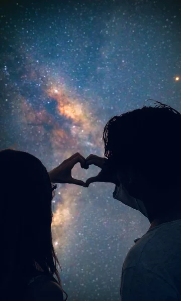 Pareja Haciendo Forma Corazón Bajo Los Cielos Estrellados —  Fotos de Stock