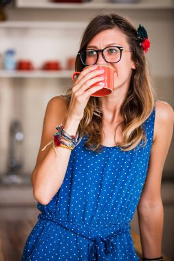 Evde çay ve kahve içen bir kadın..