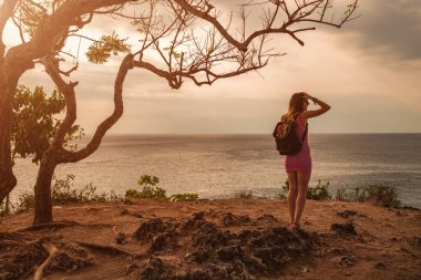 Okyanus kıyısındaki uçuruma bakan bir kadın..