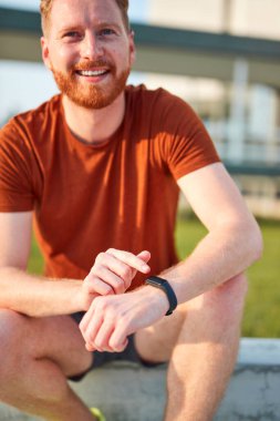 Şehir parkında egzersiz yaparken / esneme hareketleri yaparken el nöbeti tutan genç adam..