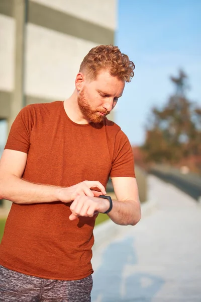 Hombre Joven Usando Reloj Mano Durante Ejercicio Estiramiento Parque Urbano — Foto de Stock