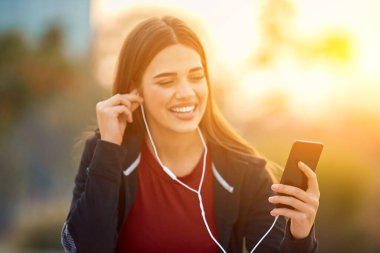 Cep telefonlu modern genç kadın koşu / egzersiz sırasında mola veriyor.