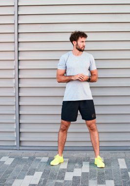Genç adam kentsel alanda egzersiz yapıyor / esniyor.