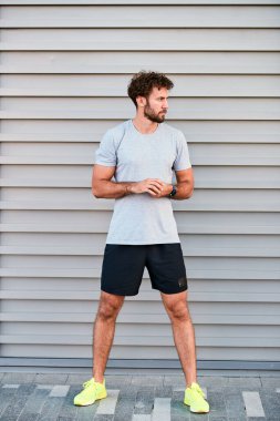 Genç adam kentsel alanda egzersiz yapıyor / esniyor.