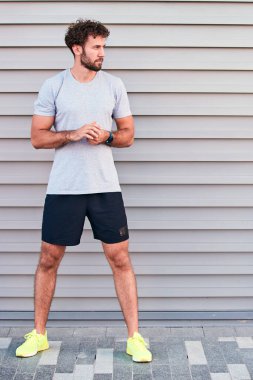 Genç adam kentsel alanda egzersiz yapıyor / esniyor.