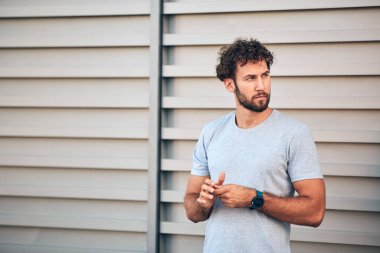 Genç adam kentsel alanda egzersiz yapıyor / esniyor.