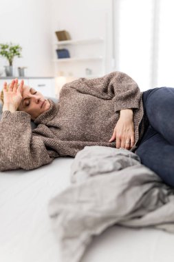 Evde mide sorunları olan yorgun bir kadın. Kanepede hasta ve hamile..