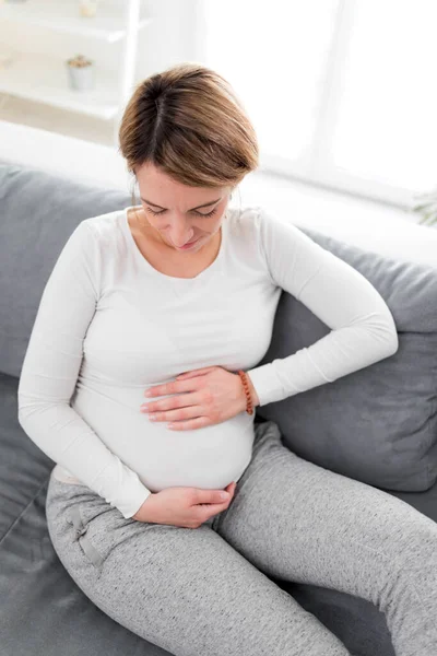 在家里的沙发上 有胃痛的疲倦的怀孕妇女 — 图库照片