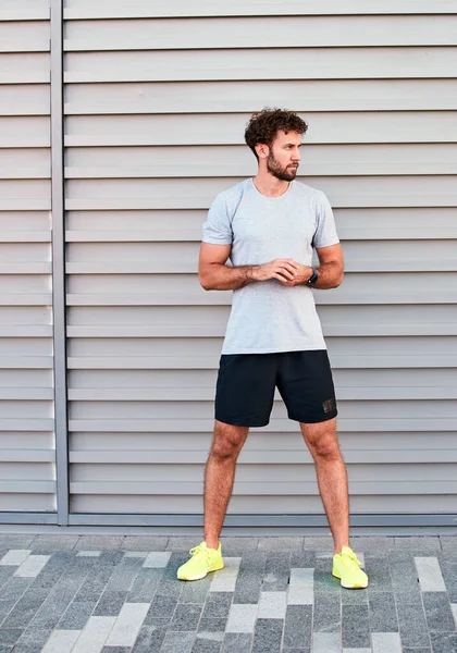 Genç adam kentsel alanda egzersiz yapıyor / esniyor.