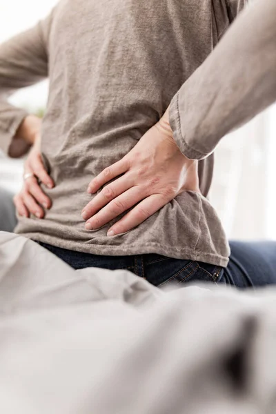 女人在床上醒来 早上舒展筋骨 后背和髋部疼痛 — 图库照片