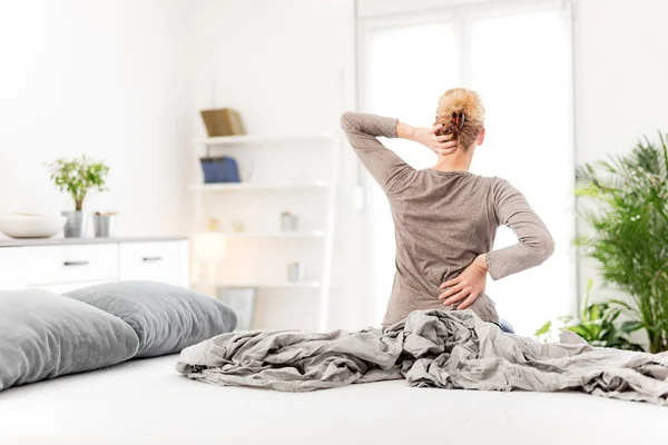 女人在床上醒来 早上舒展筋骨 背部和颈部疼痛 — 图库照片