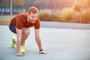 Genç modern adam şehir parkında koşuyor / egzersiz yapıyor.