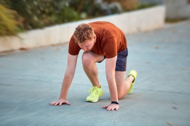 Genç modern adam şehir parkında koşuyor / egzersiz yapıyor.