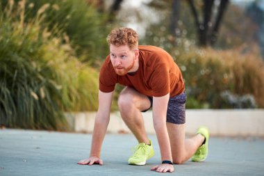 Genç modern adam şehir parkında koşuyor / egzersiz yapıyor.