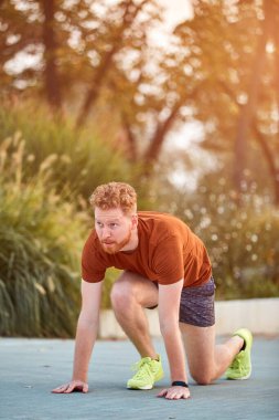 Genç modern adam şehir parkında koşuyor / egzersiz yapıyor.