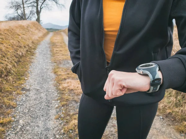 Adult woman jogging / exercising on a mountain road in nature.