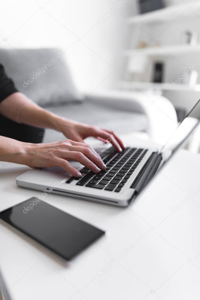 Person using laptop and typing on a keyboard.