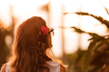 Parkta arka planda güneş ışığı olan bir kadının silueti..