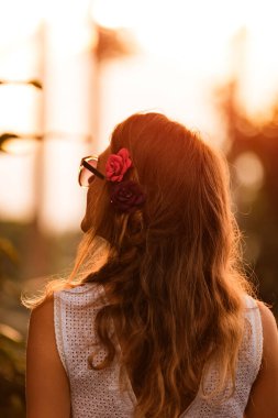 Parkta arka planda güneş ışığı olan bir kadının silueti..